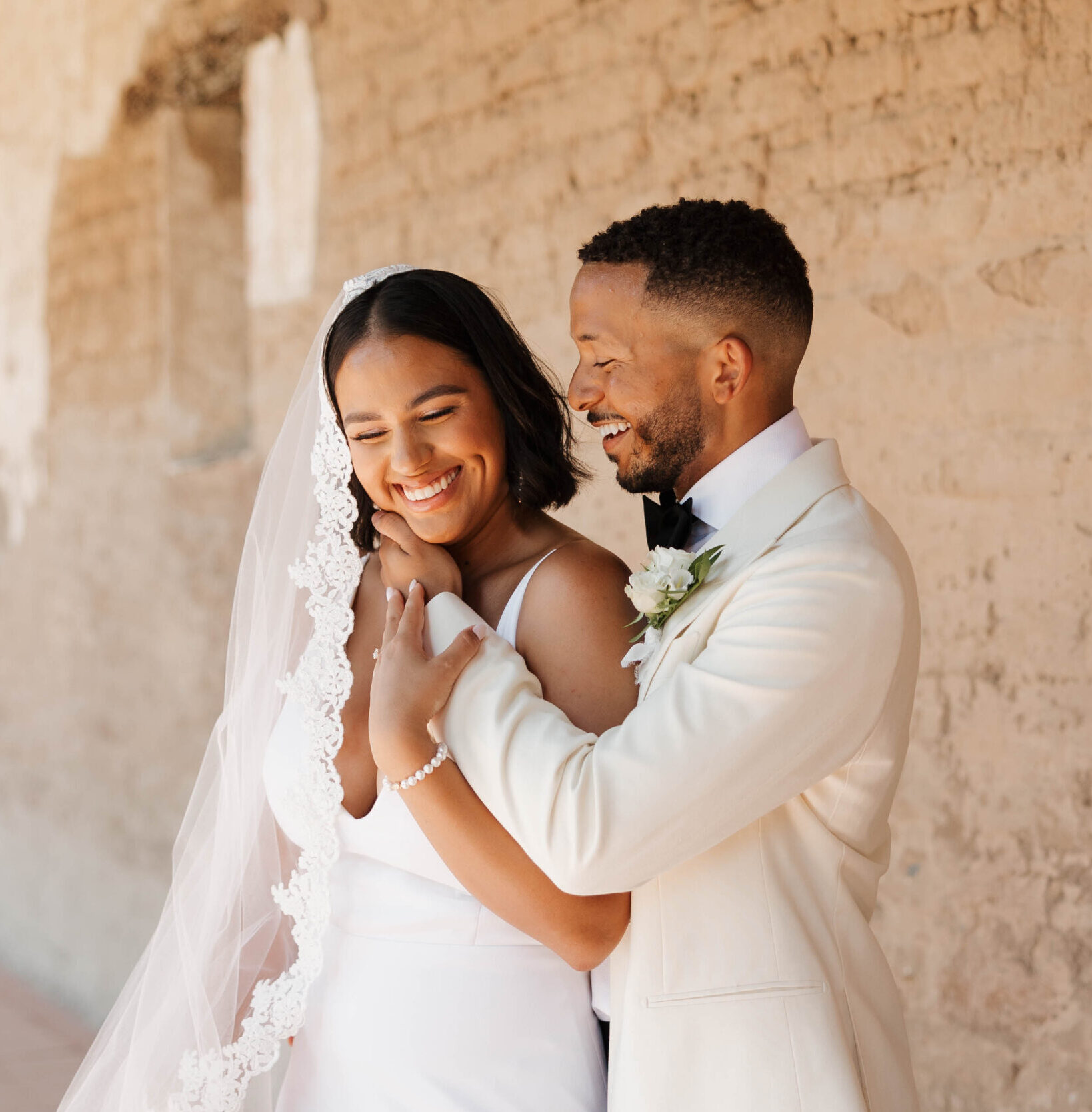 bride and groom hugging and embracing at the mission san juan capistrano